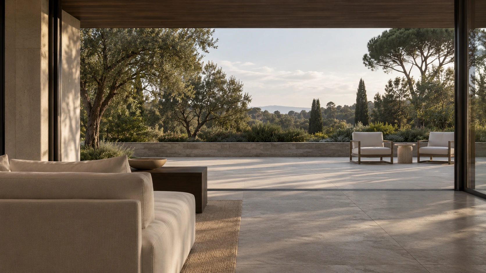 Living room opening onto a stone terrace and a sunlit garden